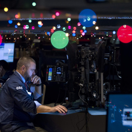 Un operador de la bolsa de Wall Street, rodeado de la decoración navideña en el parqué. REUTERS/Carlo Allegri