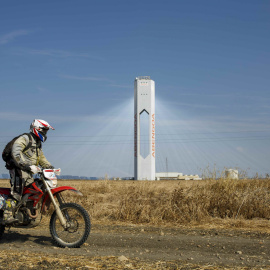 Un motocilcista pasa cerca de la torre de la planta solar 'Solúcar' de Abengoa, en la localidad sevillana de Sanlucar la Mayor. REUTERS/Marcelo del Pozo