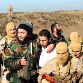 Fotograma de un vídeo cedido por la rama del Estado Islámico (EI) en la ciudad de Al Raqa que muestra a varios miembros del EI junto al presunto piloto capturado, identificado como Muaz Kasabeh. - EFE