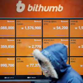 Un hombre pasa frente a un monitor que muestra la cotización de varias criptomonedas en Seúl (Corea del Sur). REUTERS/Kim Hong-Ji