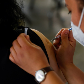 Una sanitaria administra una vacuna