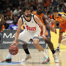 El escolta del Real Madrid, Sergio Llull, ante la defensa del alero centroafricano del Valencia Basket, Romain Sato. /EFE