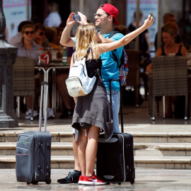 Varios turistas toman fotografías con sus teléfonos móviles por el centro de la ciudad de València. EFE/Ana Escobar