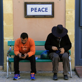 Un par de peatones sentados en un banco en la zona de seguridad administrada por la ONU en Nicosia, la única capital dividida del mundo, con el sur (griego) y el norte (turco) separada por la llamada 'Línea Verde' desmilitarizada. REUTERS /