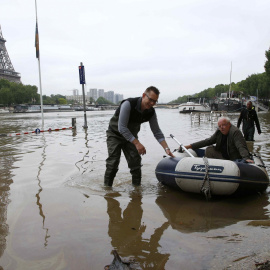 Un hombre utiliza un bote para salir de su casa flotante amarrada cerca de la torre Eiffel durante la inundación provocada por la crecida del río Sena en París , Francia.- REUTERS / Pascal Rossignol