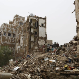 Varias personas buscan supervivientes entre los restos de varios edificios destrozados durante un bombardeo sobre el casco histórico de Saná. - EFE
