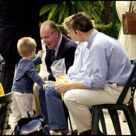 El rey juan Carlos juega con uno de sus nietos antes de que estallara el Caso Nóos.- EFE