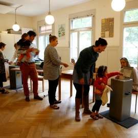Ciudadanos suizos hacen cola para votar en el referendum sobre el establecimiento de una renta básica mensual. REUTERS/Ruben Sprich