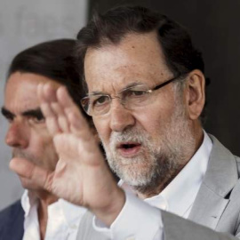 El presidente del Gobierno y del PP, Mariano Rajoy, con su antecesor, José María Aznar, en una imagen de archivo. REUTERS