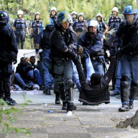 Agentes arrastran a uno de los inmigrantes atrapados en Ventimiglia. - AFP
