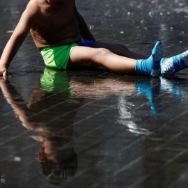 Un niño se refresca en los chorros de agua de la playa de Madrid Río. EFE/MARISCAL