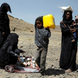 Yemeníes reciben raciones de comida de la organización Mona Relief Yemen este lunes en Saná.