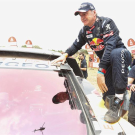 Carlos Sainz se encarama a su coche tras ganar el Dakar 2018 / EFE