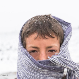 Un joven refugiado sirio se cubre para protegerse del frío en el valle de la Bekaa, en el Líbano, en enero de 2016.-  ACNUR/UNHCR/Haidar Darwish.