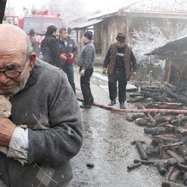 Anciano abrazando al gato superviviente tras el incendio de su casa. Facebook / NTV Radyo