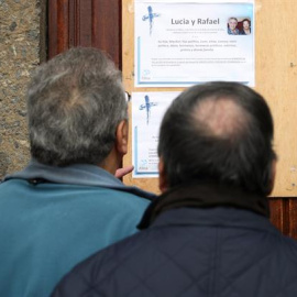 Vecinos de los fallecidos observan la esquela de los dos ancianos asesinados en Bilbao. / LUIS TEJIDO (EFE)