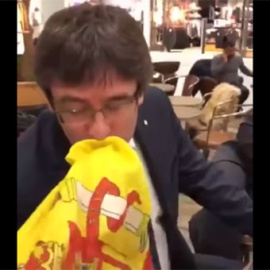 Momento en el que Carles Puigdemont besa una de las dos veces la bandera de España.