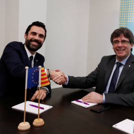 Roger Torrent y Carles Puigdemont se saludan al inicio de su reunión en Bruselas. | YVES HERMAN (REUTERS)