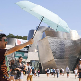 Un turista se protege del sol ante el museo Guggenheim de Bilbao, uno de los destinos demandados en vacaciones. /EFE