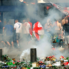 Hinchas ingleses se apartan tras lanzar un petardo en una calle llena de desperdicios y botellas de cerveza vacías. /REUTERS