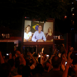 Seguidores de Bolsonaro siguen su discurso por una pantalla tras ganar las elecciones en Brasil. /REUTERS