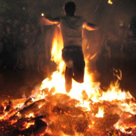 Un hombre salta una hoguera en la noche de San Juan. /TURGALICIA