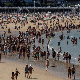 14/08/2019.- Donostiarras y visitantes pasean por la playa de La Concha de San Sebastián. / EFE - JAVIER ETXEZARRETA