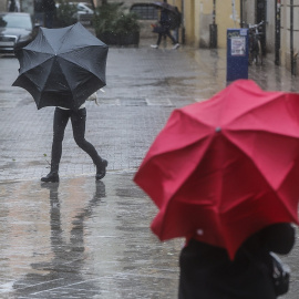 Dos personas sostienen paraguas como consecuencia de la lluvia, a 6 de febrero de 2023, en Valencia, Comunidad Valenciana (España).