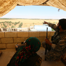 Un combatiente de las Fuerzas Democráticas Siria (SDF) problemas mientras está sentado en posición de mirar hacia fuera en el área rural occidental de Manbij, en Alepo gobernación, Siria, 13 de junio de 2016. REUTERS / Rodi Said