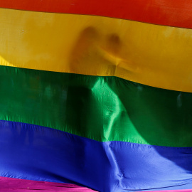 Dos personas se abrazan mutuamente tras una bandera arcoiris durante una vigilia en memoria de las víctimas del tiroteo del club gay Pulse de Orlando en Bombay, India. REUTERS/Danish Siddiqui