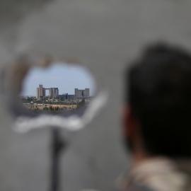 Un combatiente de las Fuerzas Democráticas sirias toma posición mientras observa las fábricas de Manbij donde se colocan las milicias del Estado Islámico, en Alepo,Siria.REUTERS / Rodi Said