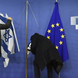 Empleados de la Comisión Europea retiran la bandera israelí en Bruselas, en una imagen de archivo. / AFP - JOHN THYS