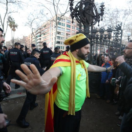 Un hombre se interpone entre los Mossos D'esquadra y los manifestantes durante las protestas frente al Parlament. EFE/Toni Albir