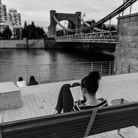 Mujer leyendo en un banco.