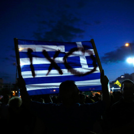 Un manifestante sostiene una bandera griega durante una manifestación contra la austeridad en Atenas, Grecia.- REUTERS / Alkis Konstantinidis