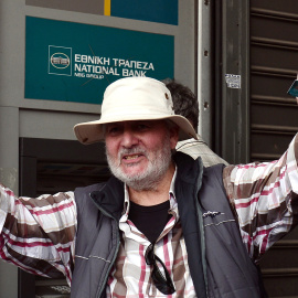 Un hombre celebra ante los medios de comunicación que ha sacado los 60 euros diarios de los que puede disponer cada ciudadano en Grecia tras decretarse el corralito.- AFP PHOTO / Louisa GOULIAMAKI