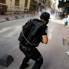 Un policía antidisturbios turno dispara balas de goma contra los participantes en la marcha en estambul por los derechos de los transexuales. REUTERS/Osman Orsal