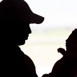 Un padre sostiene a su bebé afectado por la microcefalia que produce el virus Zika. EFE/Percio Campos