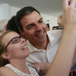 El secretario general del PSOE, Pedro Sánchez, se hace una fotografía con una simpatizante durante el acto electoral con las Juventudes Socialistas, en el Centro Cultural Tomás y Valiente, en la localidad madrileña de Fuenlabrada./ EFE