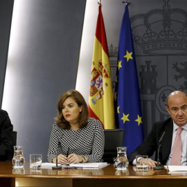 La vicepresidenta del Gobierno Soraya Sáenz de Santamaría junto a los ministros de Justicia, Rafael Catalá, (iz),y Economía, Luis de Guindos. /EFE
