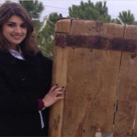 La joven siria de origen español Anna Massaad, con la puerta recuperada del monasterio de San Sergio y San Baco de Malula.