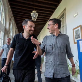 El exvicepresidente del Gobierno de España, Pablo Iglesias y el cofundador de Podemos, Juan Carlos Monedero, conversan a su llegada a una mesa redonda en San Lorenzo de El Escorial, a 18 de julio de 2022.