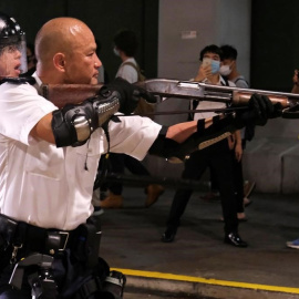 Un oficial de policía de Hong Kong apunta con un arma a los manifestantes. / TYRONE SIU (REUTERS)