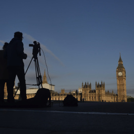 Un operador de cámara toma imágenes del amanecer ante las Casas del Parlamento en Londres (Reino Unido) hoy, 24 de junio de 2016. Los británicos se decantaron en referéndum por la "libertad" frente al "control" de la Unión Europea (UE), com