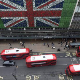 Peatones caminan por Oxford Street donde se colocó una bandera británica en la fachada de unos grandes almacenes en Londres durante la jornada de referéndum por el Brexit. EFE