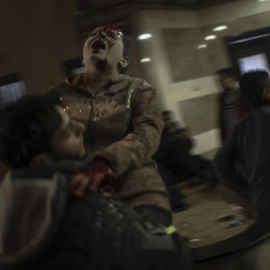 Un hombre traslada a una mujer herida tras un ataque de Israel a un hospital de la Franja de Gaza, a 17 de diciembre de 2023.