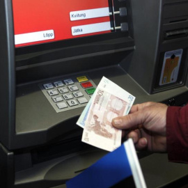 Imagen de archivo de un hombre sacando dinero de un cajero. EFE