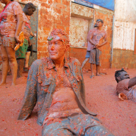 28/08/2019 - Un hombre se sienta en la acera tras la Tomatina celebrada en el pueblo Bunyol, donde un año más es el escenario de la batalla hortofrutícola más colorada del mundo. REUTERS/Heino Kali