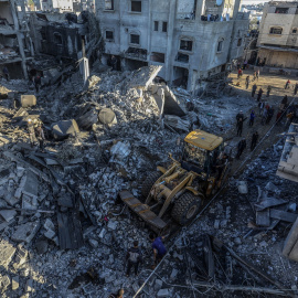 Palestinos remueven los escombros de las casas dañadas en Rafah tras un bombardeo israelí el 15 de diciembre.