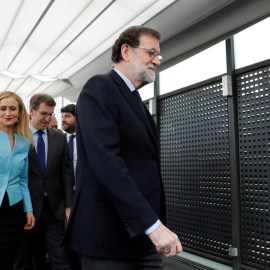 La presidenta de la Comunidad de Madrid, Cristina Cifuentes, tras el jefe del Gobierno y líder del PP, Mariano Rajoy, y junto al presidente de la Xunta de Galicia, Alberto Núñez Feijóo, tras posar para la foto de familia de los barones del 